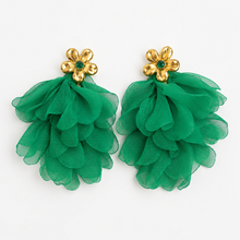 Load image into Gallery viewer, A pair of statement earrings featuring layered green ruffled organza fabric drops attached to gold flower-shaped studs with small green center stones, shown on a plain white background.
